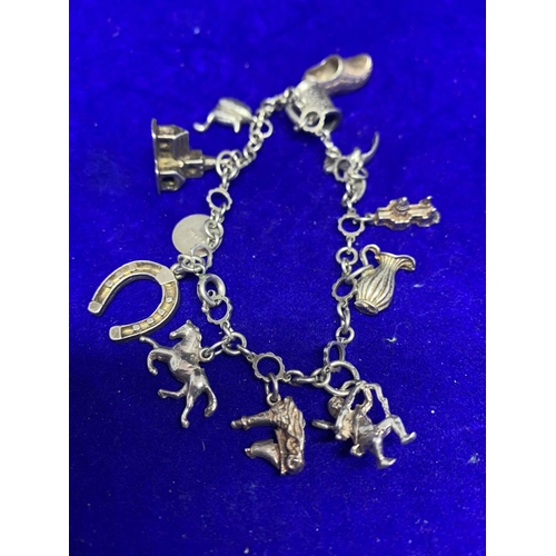 641 - A SILVER CHARM BRACELET WITH TWELVE VARIOUS CHARMS