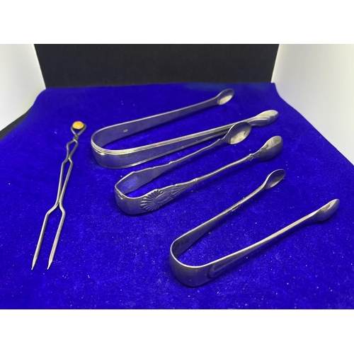 664 - THREE PAIRS OF HALLMARKED SILVER SUGAR TONGS AND A FORK WITH AMBER COLOURED STONE