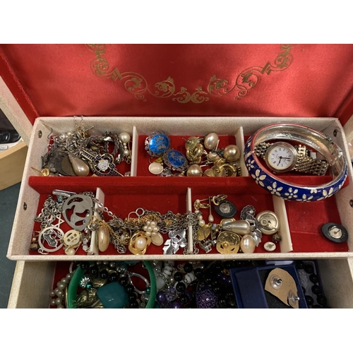 206 - A CREAM HINGED JEWELLERY BOX CONTAINING A VARIETY OF COSTUME JEWELLERY