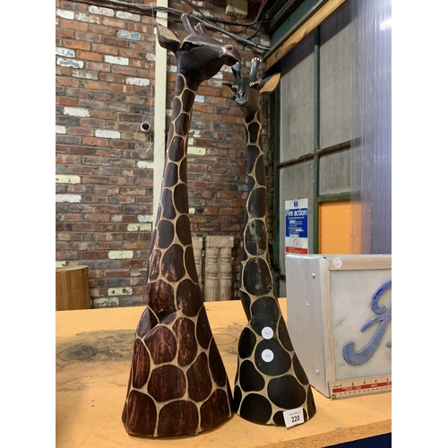 220 - A PAIR OF WOODEN ORNAMENTAL GIRAFFES' HEADS HEIGHTS APPROXIMATELY 68CM AND 70CM