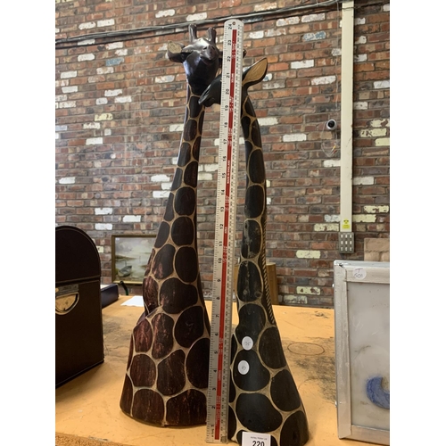 220 - A PAIR OF WOODEN ORNAMENTAL GIRAFFES' HEADS HEIGHTS APPROXIMATELY 68CM AND 70CM