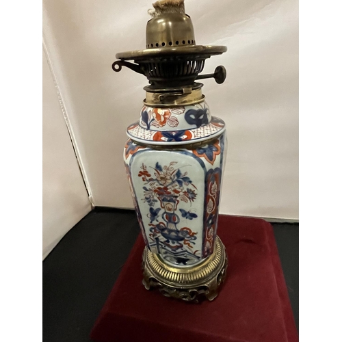 719 - AN ORIENTAL CERAMIC AND BRASS OIL LAMP