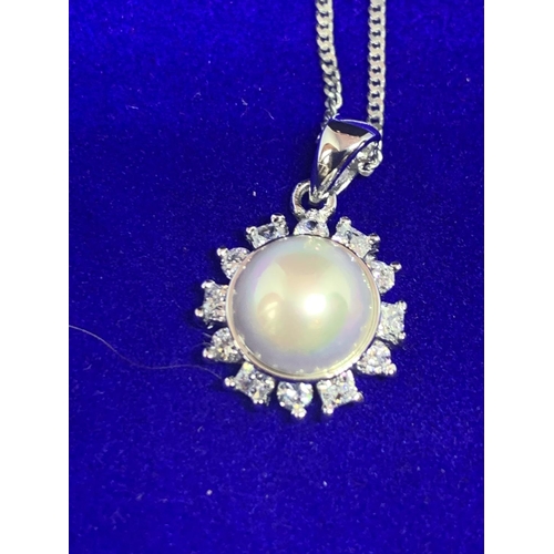 514 - A SILVER CHAIN MARKED 925 WITH A PEARLISED AND CLEAR STONE PENDANT IN A PRESENTATION BOX