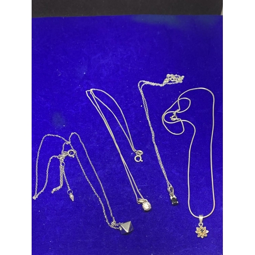 596 - FOUR SILVER NECKLACES MARKED 925 WITH PENDANTS TO INCLUDE A CLEARSTONE, FLOWER ETC