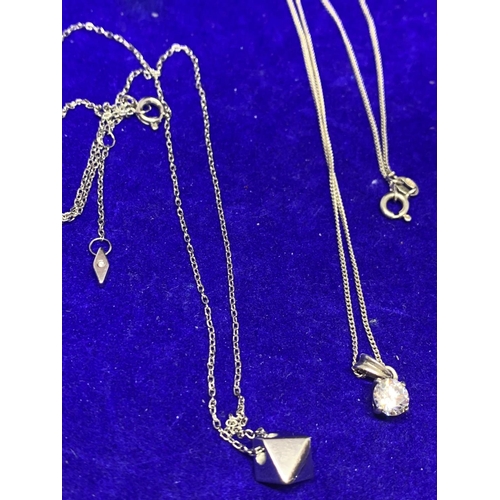 596 - FOUR SILVER NECKLACES MARKED 925 WITH PENDANTS TO INCLUDE A CLEARSTONE, FLOWER ETC