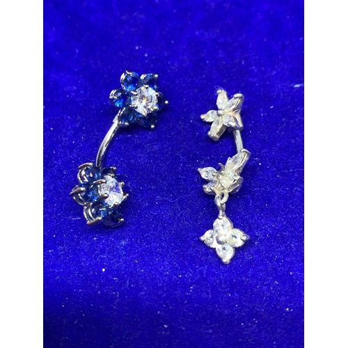 654 - TWO SILVER BELLY BUTTON BARS WITH COLOURED STONE FLOWER DESIGN