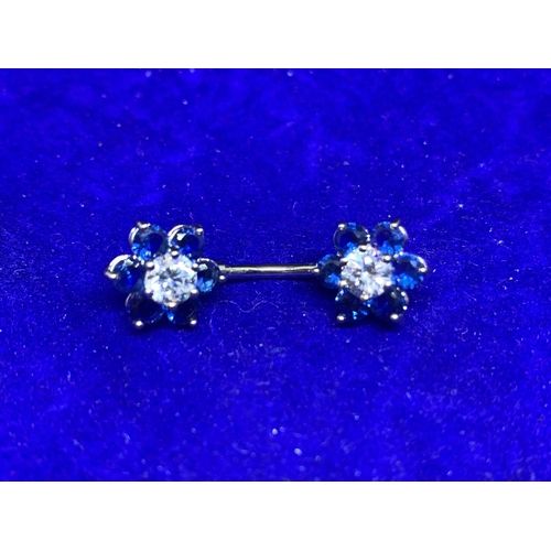 654 - TWO SILVER BELLY BUTTON BARS WITH COLOURED STONE FLOWER DESIGN