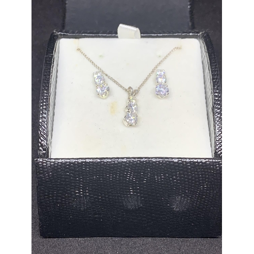 519 - A SILVER NECKLACE WITH A THREE CLEAR STONE DROP PENDANT AND MATCHING EARRINGS IN A PRESENTATION BOX