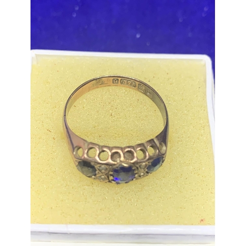 502 - A 9 CARAT YELLOW GOLD RING WITH THREE IN LINE BLUE STONES GROSS WEIGHT APPROXIMATELY 2.1 GRAMS