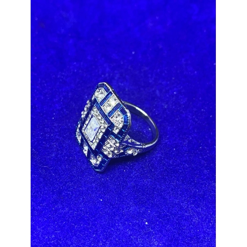 535 - A LARGE RECTANGULAR BLUE AND CLEAR STONE ART DECO STYLE DRESS RING