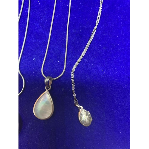 545 - FOUR SILVER NECKLACES MARKED 925 WITH PENDANTS TO INCLUDE A LOCKET, SHELL TEARDROP, HEART AND AN ABS... 