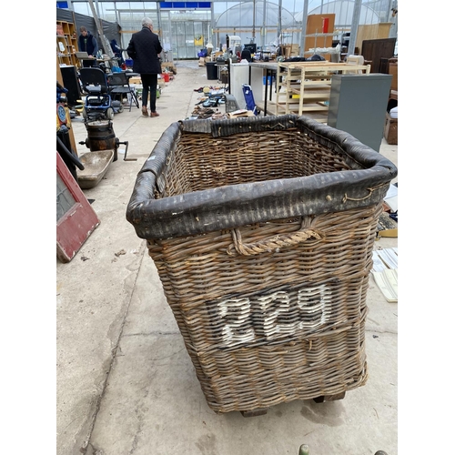 1287 - A LARGE VINTAGE WICKER LAUNDRY TROLLEY ON METAL WHEELS