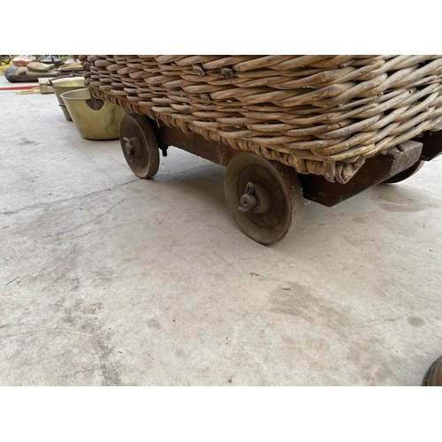 1287 - A LARGE VINTAGE WICKER LAUNDRY TROLLEY ON METAL WHEELS