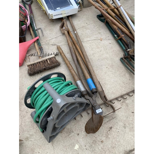 1391 - AN ASSORTMENT OF VINTAGE GARDEN TOOLS TO INCLUDE A RAKE, A HOE AND A HOSE PIPE ETC