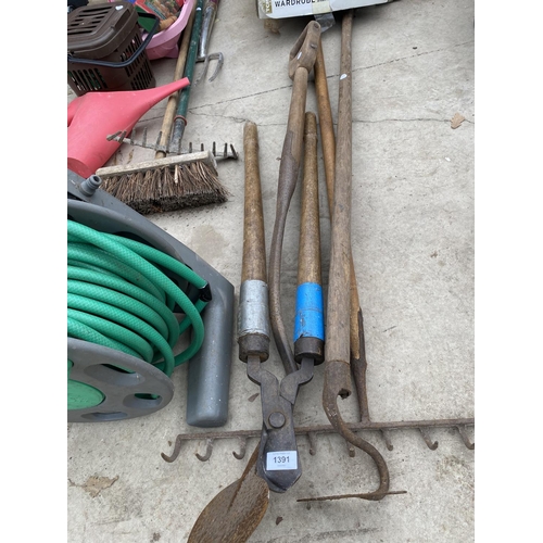 1391 - AN ASSORTMENT OF VINTAGE GARDEN TOOLS TO INCLUDE A RAKE, A HOE AND A HOSE PIPE ETC