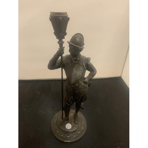 21 - A VINTAGE SPELTER CANDLESTICK IN THE FORM OF A HISTORICAL FIGURINE