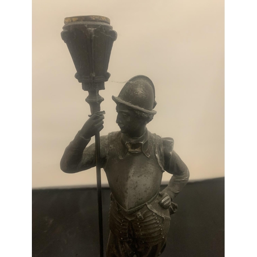 21 - A VINTAGE SPELTER CANDLESTICK IN THE FORM OF A HISTORICAL FIGURINE