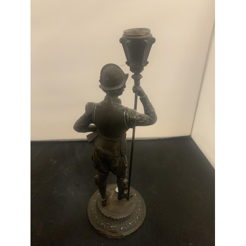 21 - A VINTAGE SPELTER CANDLESTICK IN THE FORM OF A HISTORICAL FIGURINE