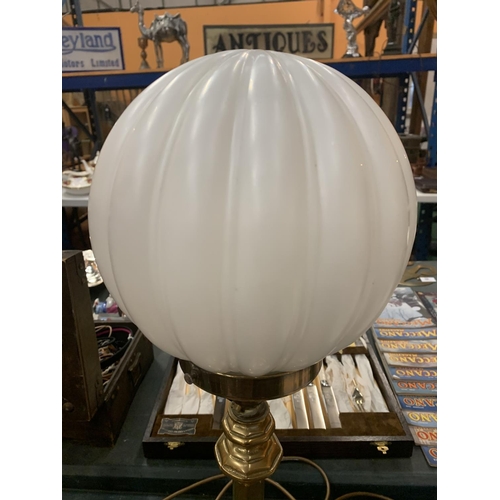 106 - A BRASS TABLE LAMP WITH WHITE GLOBE SHADE BELIEVED IN WORKING ORDER BUT NO WARRANTY