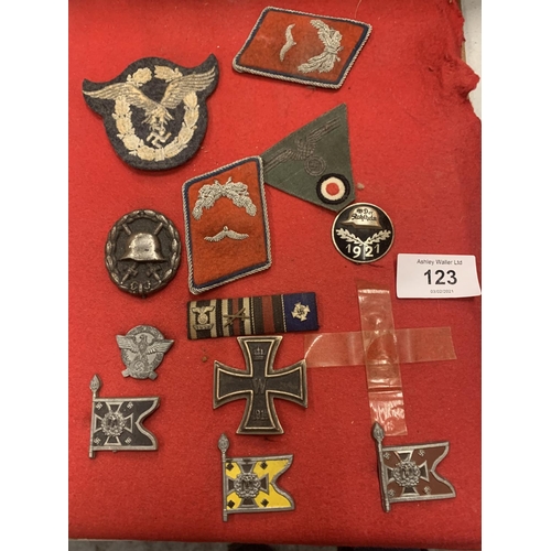 123 - A SMALL VINTAGE LEATHER SUITCASE AND AN ASSORTMENT OF WAR MEDALS AND FABRIC MILITARY PATCHES