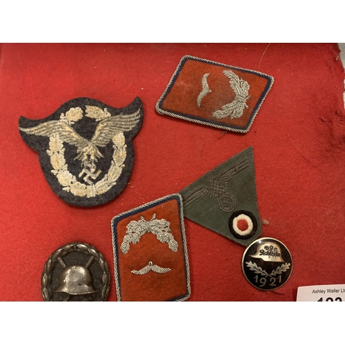 123 - A SMALL VINTAGE LEATHER SUITCASE AND AN ASSORTMENT OF WAR MEDALS AND FABRIC MILITARY PATCHES