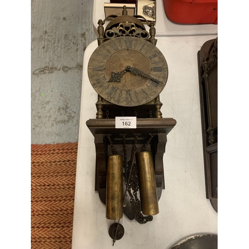 162 - A BRASS LANTERN CLOCK WITH WEIGHTS ON A WOODEN SUPPORT