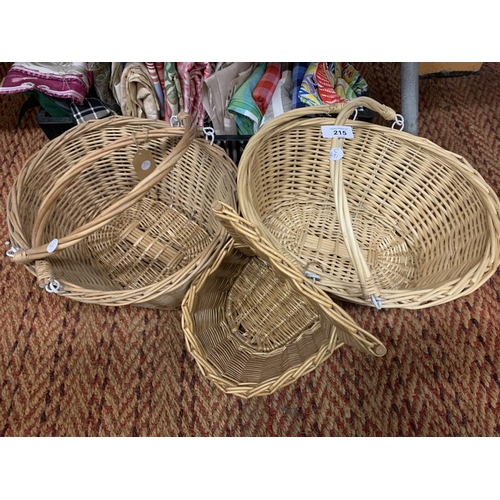 215 - THREE WICKER BASKETS AND AN ASSORTMENT OF CLOTH