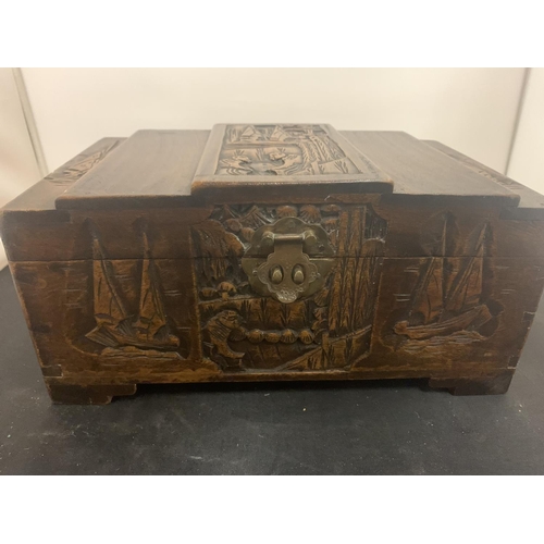 67 - A CARVED WOODEN LIDDED BOX WITH BRASS CLASP