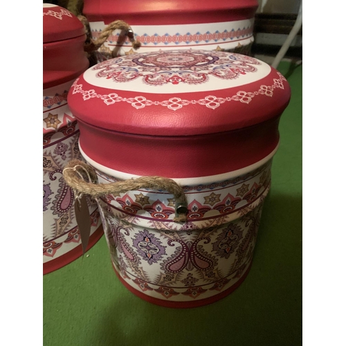 415 - A SET OF THREE GRADUATED PINK PAISLEY LEATHER EFFECT LIDDED STORAGE STOOLS