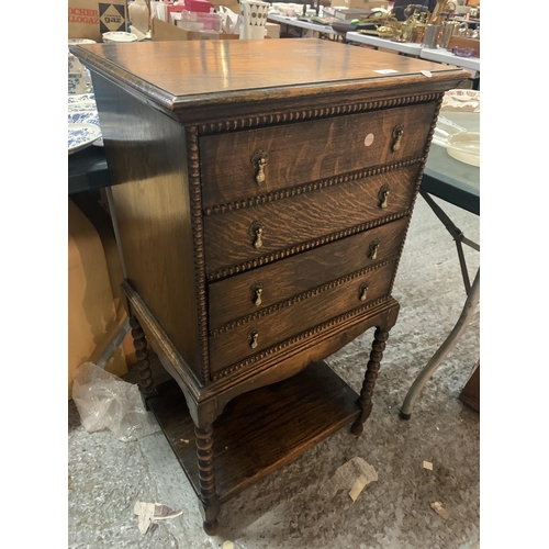 253 - AN OAK MUSIC CABINET WITH FOUR FALL FRONT DRAWERS AND LOWER SHELF ON BARLEY TWIST SUPPORTS