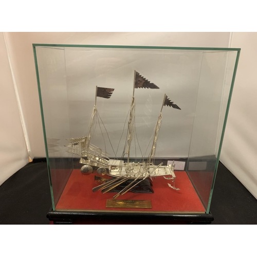 16A - A WHITE METAL POSSIBLY SILVER MODEL OF A CHINESE JUNK IN A GLASS PRESENTATION CASE