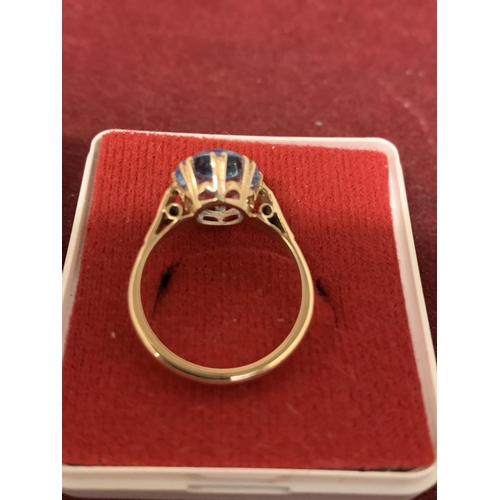 594 - A 9 CARAT GOLD RING WITH A  PALE BLUE STONE 3.21G