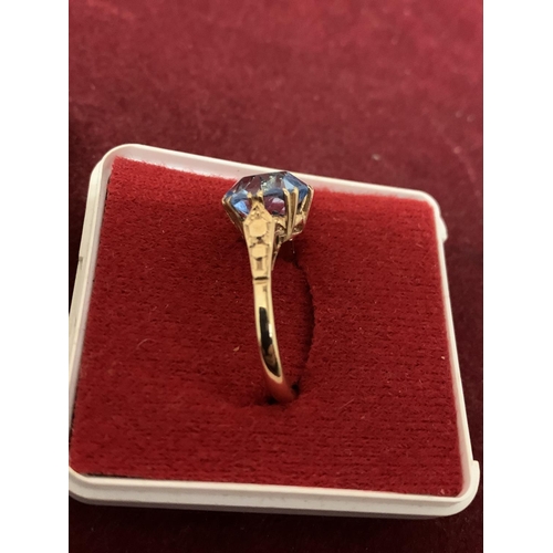 594 - A 9 CARAT GOLD RING WITH A  PALE BLUE STONE 3.21G