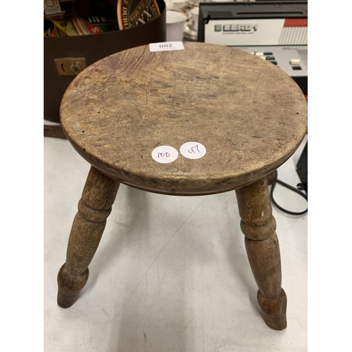 200 - A VINTAGE WOODEN FOUR LEGGED MILKING STOOL