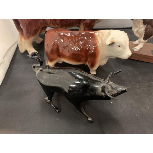 29 - FOUR HEREFORD BULL ORNAMENTS TO INCLUDE A FURTHER SMALL BLACK BULL
