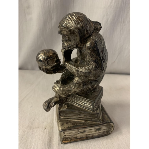 2A - A CAST WHITE METAL TABLE LIGHTER IN THE FORM OF A MONKEY HOLDING A SKULL