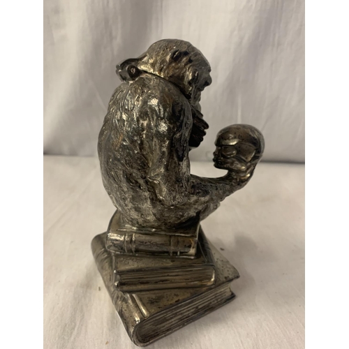 2A - A CAST WHITE METAL TABLE LIGHTER IN THE FORM OF A MONKEY HOLDING A SKULL