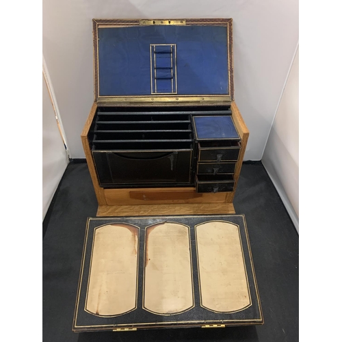 36 - A VINTAGE WOODEN WRITING SLOPE INCORPORATING THREE SMALL DRAWERS AND LETTER RACK WITHIN THE LEATHER ... 