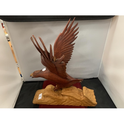 8 - A WOODEN CARVED BIRD OF PREY CATCHING A FISH