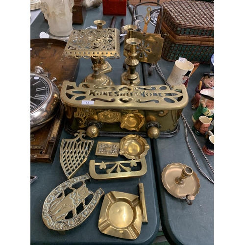 82 - A QUANTITY OF BRASS WARE TO INCLUDE A 'HOME SWEET HOME' FENDER, CANDLESTICKS ETC