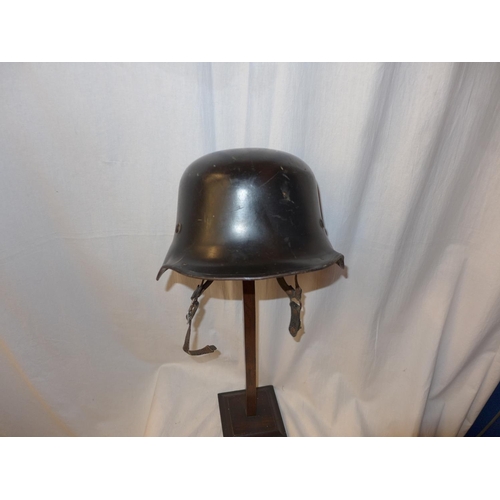 527 - A WORLD WAR II PERIOD BLACK PAINTED GERMAN HELMET, WITH LEATHER LINER