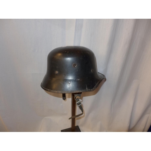 527 - A WORLD WAR II PERIOD BLACK PAINTED GERMAN HELMET, WITH LEATHER LINER