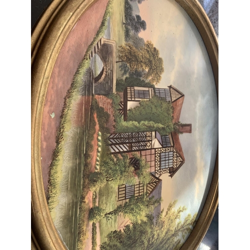 719 - A FRAMED OVAL CERAMIC PLAQUE OF LITTLE MORETON HALL BY JOHN THORLEY