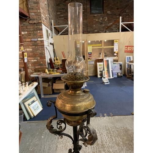 219A - A TALL BRASS AND IRON STAND WITH AN OIL LAMP