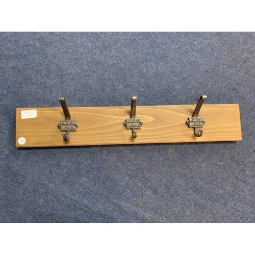 271A - A SET OF THREE COAT HOOKS 'MADE IN BRITAIN' MOUNTED ON A WOODEN BACKING