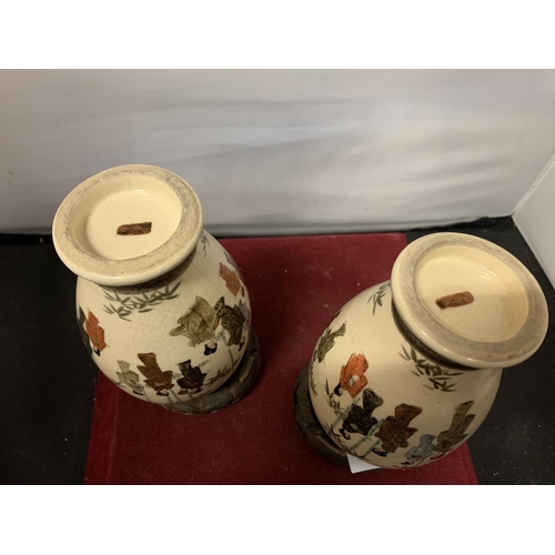 695 - A PAIR OF DECORATIVE SATSUMA VASES (ONE CHIPPED TO THE RIM) WITH A PAIR OF WOODEN BASES  H:16CM