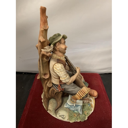 722A - A CAPODIMONTE ORNAMENT OF A GAMEKEEPER ASLEEP AND HIS DOG