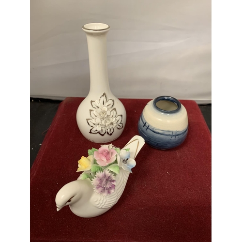 749 - THREE ROYAL DOULTON ITEMS TO INCLUDE A SMALL BLUE FLAMBE VASE, A BUD VASE AND A DOVE WITH FLOWERS