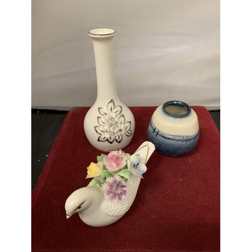 749 - THREE ROYAL DOULTON ITEMS TO INCLUDE A SMALL BLUE FLAMBE VASE, A BUD VASE AND A DOVE WITH FLOWERS