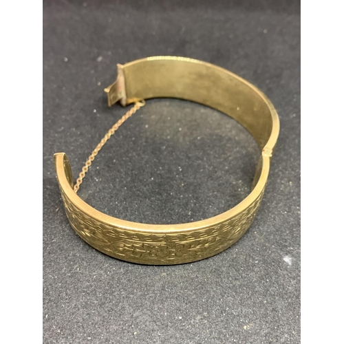 550 - A 9 CARAT GOLD BANGLE MARKED WAX FILLED GROSS WEIGHT 39.4 GRAMS